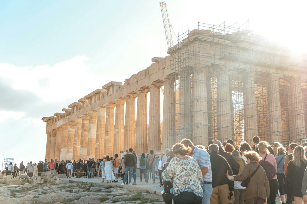 Visitors gather at the iconic Parthenon in Athens, Greece during daylight.